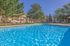 Inviting outdoor pool with crystal clear water, surrounded by lush trees and comfortable lounge chairs, perfect for relaxation and enjoyment.
