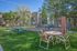 Lush outdoor area with a picnic table and seating, adjacent to a fenced playground, perfect for relaxation in a vibrant apartment community setting.