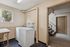 Modern laundry area featuring efficient washers beside a large window, with adjacent access to staircase, offering convenience and functionality.