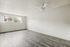 Bright and airy room with large windows, contemporary gray flooring, and a sleek ceiling fan, ideal for stylish modern living.