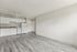 Modern apartment interior with open-concept kitchen featuring sleek white cabinetry, elegant countertops, and stylish vinyl flooring.
