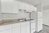 Bright, modern kitchen with sleek white cabinetry, durable countertops, and contemporary appliances, perfect for culinary creativity.
