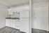 Charming kitchen space with sleek white cabinetry, modern appliances, and wood-style flooring, perfect for cozy home cooking.