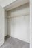 Bright and spacious closet with plush carpet and a sturdy wire shelf, ideal for smart storage solutions.