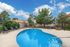Inviting outdoor swimming pool area surrounded by lush trees, modern lounge chairs, and a stylish fire pit for cozy gatherings.