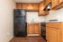 Chic kitchen space featuring modern black appliances, elegant wooden cabinets, and sleek countertops, perfect for culinary enthusiasts.