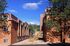 Charming apartment buildings with a breathtaking mountain view, surrounded by lush greenery and vibrant skies.