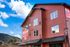 Charming mountain view apartments with red siding and modern design, now leasing with breathtaking natural surroundings.