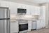 Sleek and modern kitchen featuring stainless steel appliances, elegant white cabinetry, and a spacious countertop.