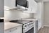 Sleek modern kitchen featuring stainless steel appliances, elegant white cabinetry, and a smooth electric stove.