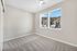 Bright and inviting bedroom featuring plush carpet and large windows with stunning hillside views.