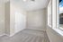 Bright and airy bedroom with a large window offering scenic views and ample natural light, featuring soft carpet flooring and sleek sliding closet doors.