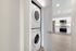 Modern apartment kitchen with sleek stainless steel appliances and a convenient in-unit stacked washer and dryer for added luxury.