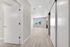 Bright and airy apartment interior featuring elegant light wood flooring, modern lighting, and a scenic large window view.