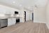 Modern open-concept kitchen with sleek white cabinetry, stainless steel appliances, and wood-style flooring, perfect for stylish living.
