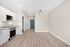 Modern apartment interior featuring a sleek kitchen with stainless steel appliances, spacious living area with wooden flooring, and elegant lighting fixtures.