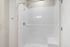 Bright, modern shower area with sleek white tiles and a stylish chrome rain shower head.