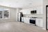 Bright, modern kitchen with sleek white cabinetry, stainless steel appliances, and scenic window view.