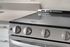 Sleek modern kitchen appliance with a smooth black cooktop and stainless steel knobs, adding elegance to any culinary space.