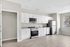 Modern kitchen space featuring sleek white cabinetry, stainless steel appliances, and elegant hardwood flooring in a bright, inviting setting.
