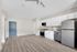 Modern kitchen with sleek stainless steel appliances, white cabinetry, and elegant hardwood flooring.