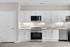 Modern kitchen with sleek white cabinets, stainless steel appliances, and elegant lighting, perfect for culinary enthusiasts.