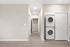 Modern hallway with elegant wood flooring, featuring a built-in washer and dryer for added convenience.