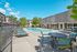 Inviting outdoor pool area with stylish lounge chairs and shaded seating, surrounded by lush greenery and modern architecture, perfect for relaxation and sunbathing.