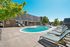 Inviting outdoor pool area with sun loungers and lush greenery at Chateau Apartments.