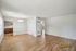 Bright open-plan living and dining area with sleek wood flooring and modern kitchen access, offering a spacious and stylish setting at Chateau Apts.