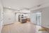 Bright and modern open-concept kitchen and living area with sleek appliances, island counter, and large sliding doors leading to a sunlit balcony at Chateau Apartments.