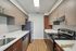 Modern galley kitchen with sleek stainless steel appliances, elegant wood cabinets, and pristine countertops at Chateau Apartments.
