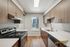 Sleek modern kitchen with stainless steel appliances, elegant wood cabinetry, and natural light streaming through the window.