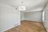 Inviting living area with elegant chandelier, rich hardwood flooring, and abundant natural light perfect for relaxation.
