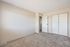 Bright and spacious bedroom with plush carpeting, a cozy neutral wall color, and ample closet space.