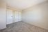 Spacious, light-filled bedroom with plush carpeting and sleek double-door closet.