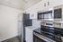 Modern kitchen with sleek stainless steel appliances, white cabinetry, and a spacious countertop.