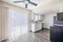Bright and modern kitchen with sleek stainless steel appliances, stylish ceiling fan, and elegant hardwood floors, perfect for contemporary living.