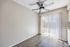 Bright room with sleek wooden floors, contemporary ceiling fan, and large sliding glass door leading to a private patio.