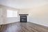 Bright living room with elegant hardwood floors, a modern black fireplace, and large window inviting natural light.