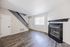 Bright and welcoming living room with sleek wood flooring, modern fireplace, and stylish staircase.