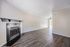 Spacious living room with elegant hardwood floors, featuring a cozy fireplace and large windows for abundant natural light.