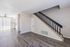 Bright open layout with modern laminate flooring and a sleek staircase, ideal for stylish living.
