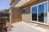Charming outdoor patio with a warm brown exterior and sliding glass doors, perfect for relaxing afternoons and seamless indoor-outdoor living.