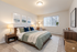 Inviting bedroom featuring a cozy bed with green and blue accents, warm lighting, and modern decor in a serene setting.