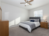 Bright and cozy bedroom with modern furnishings, featuring a plush bed, stylish wooden furniture, and soft natural light from a large window.