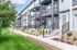 Charming modern townhouses featuring elegant balconies and lush green landscaping.