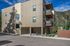 Modern apartment building exterior with balconies, located in a scenic mountain setting, offering a clean and contemporary design.
