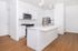 Modern kitchen with sleek white cabinetry, stainless steel appliances, and a spacious island in an open-concept layout.