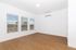 Bright and airy room with large windows, sleek hardwood flooring, and a modern air conditioning unit.
